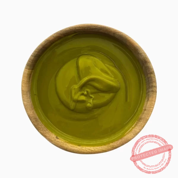 Green pistachio paste in a wooden bowl seen from above.