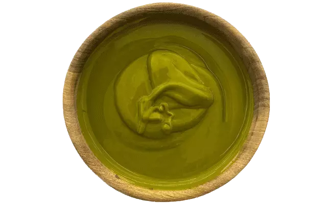 The picture shows a sample of green pistachio paste with a silky-smooth and fluid texture.