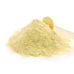 A pile of date sugar and a spoon scooping date powder