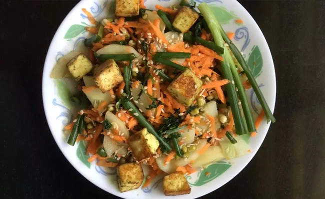 The picture shows an Asian-style tofu salad from a date syrup recipe.