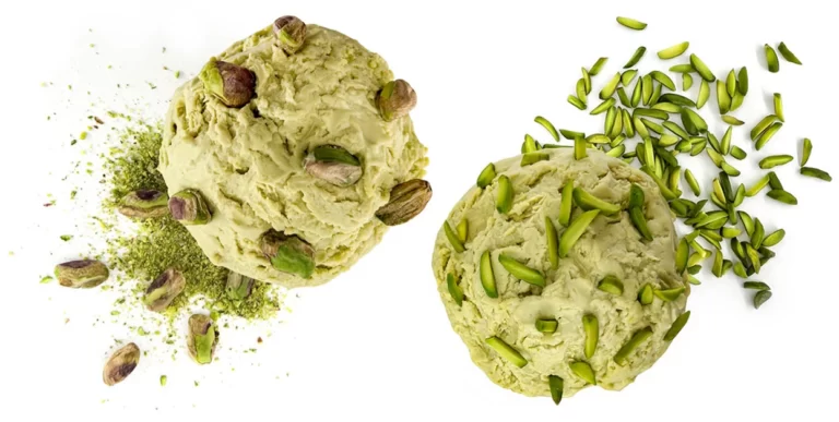 The picture shows a cup of ice cream topped with whole pistachio kernels, in the view from above with The picture shows a cup of ice cream topped with slivered pistachios, in the view from above