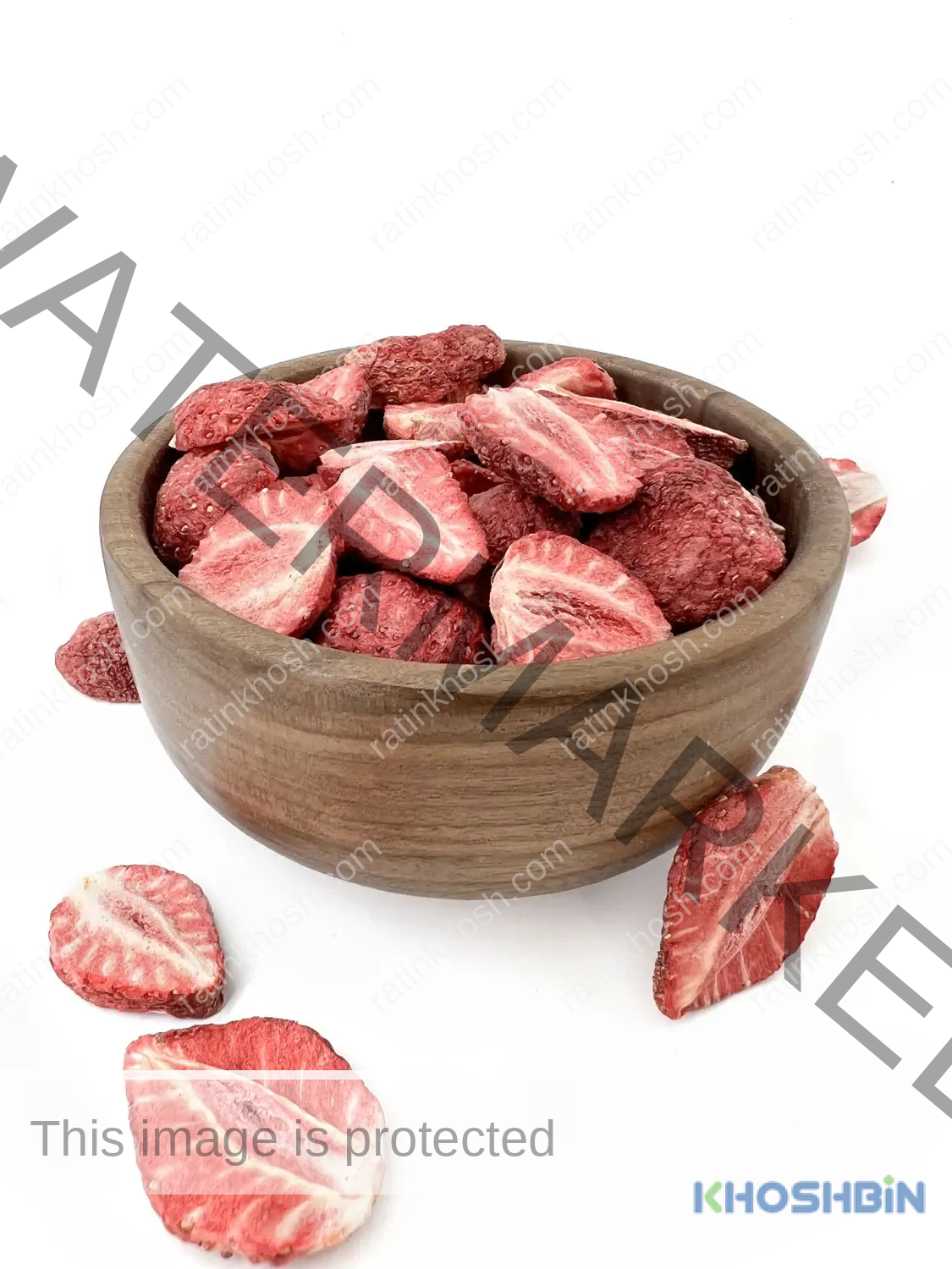 four slices of freeze dried strawberry next to a bowl of freeze dried strawberry slices and a few scattered strawberry pieces