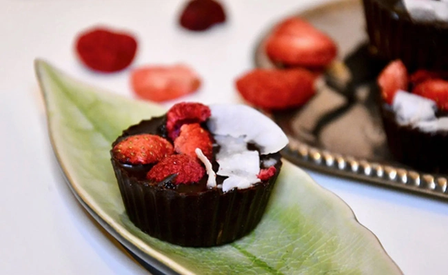 A chocolate cupcake decorated with freeze dried strawberries