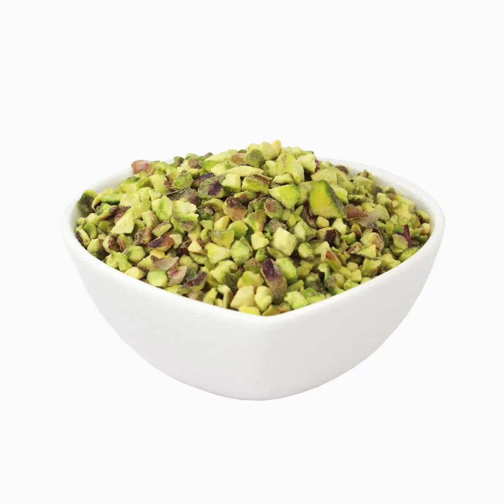 Pistachio granules in a heart-shaped bowl from a side view