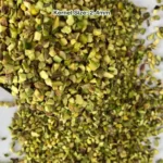 Regular pistachio granules have light green meat and brown skins, shown from a close view