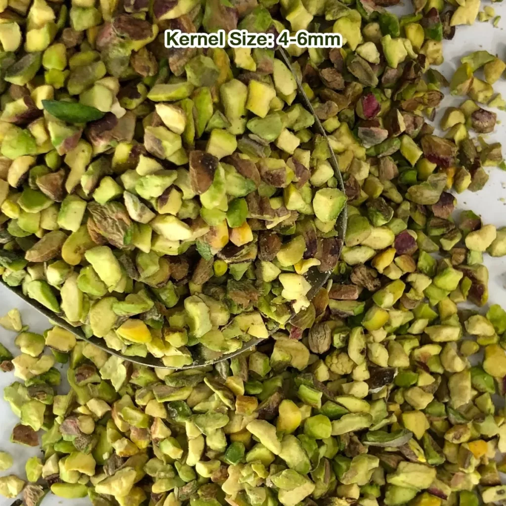 Regular pistachio granules with light green meat and brown skins, from a close view