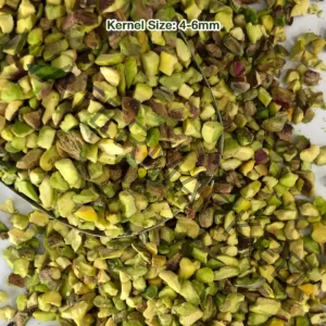 Regular pistachio granules with light green meat and brown skins, from a close view