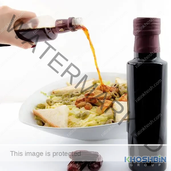 Someone is applying date balsamic vinegar to their salads