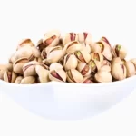 Side view of Fandoghi (round) pistachios in a bowl