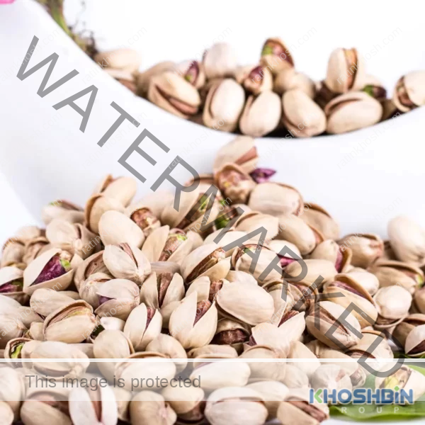 A mass or pile of jumbo pistachio next to a bowl