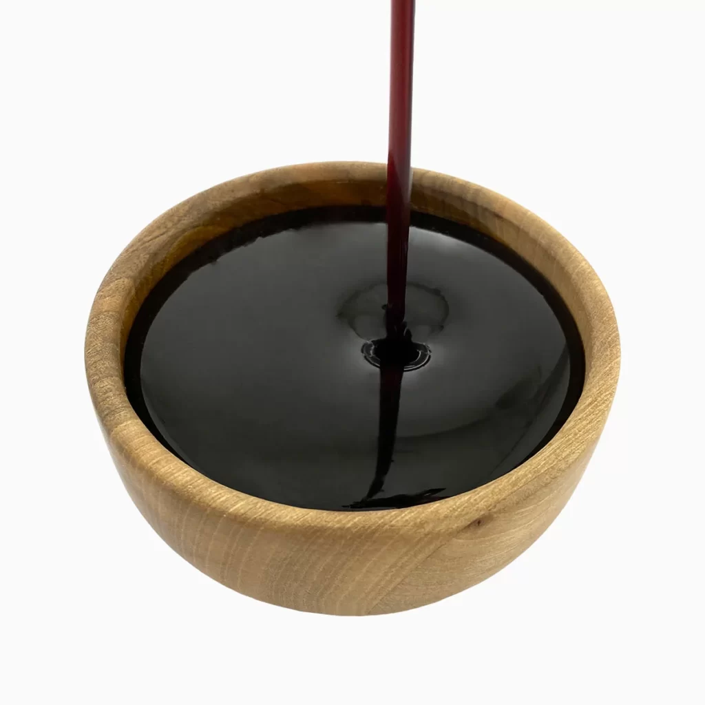 a wooden bowl filled with date syrup