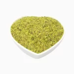 Regula pistachio powder in a heart-shaped bowl from a top view